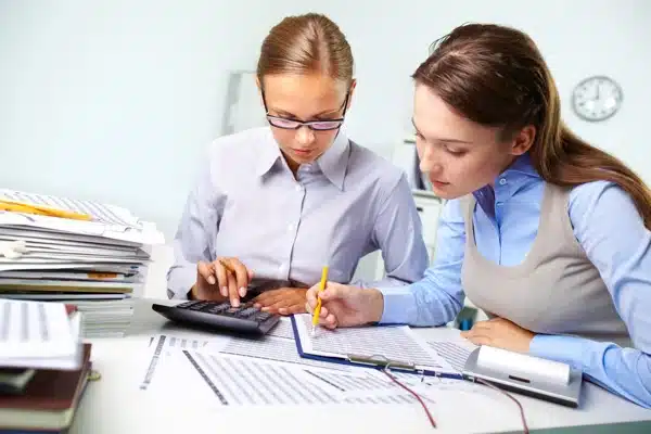 Actuaire analysant des tableaux financiers avec une collègue au bureau