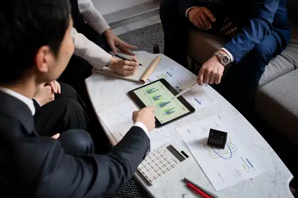 Analyse de graphiques financiers sur tablette entre professionnels